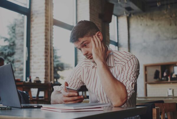 Frustrated Man Looking At His Laptop In A Cafeteria